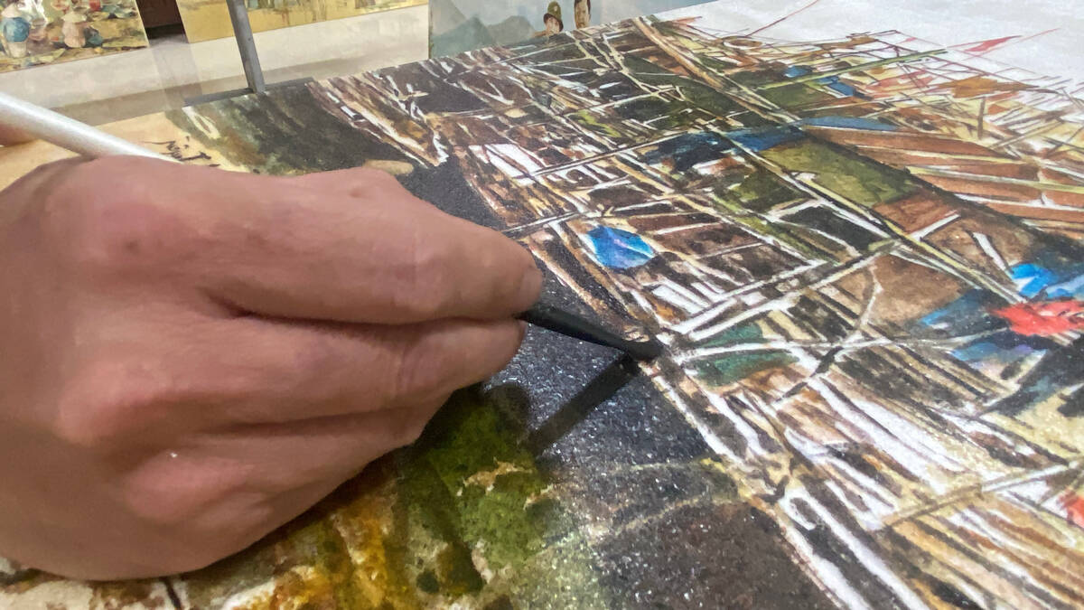 Anh Đinh Công Tuyến (phường Hiệp Hoà, Quảng Ninh) đang hoàn thiện bức tranh bột điệp. Ảnh: Nguyễn Huệ