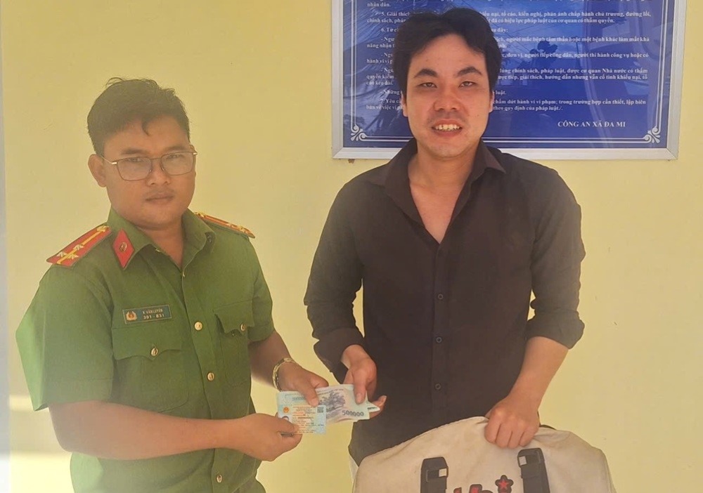 Công an xã La Dạ trao trả chiếc túi cho người đánh rơi. Ảnh: Công an