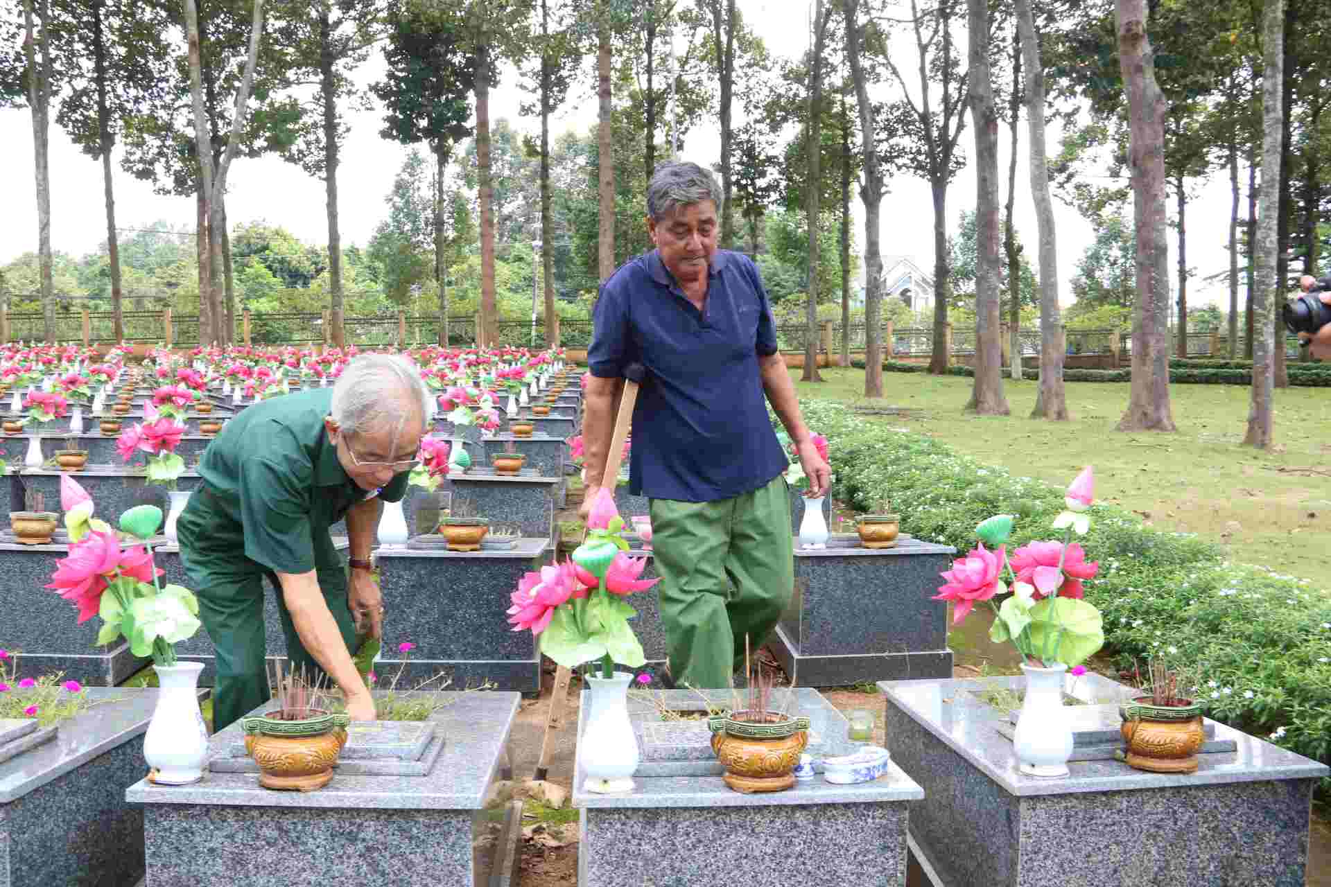 Veterans in Phuoc Long take care of martyrs' graves at Phuoc Long Martyrs' Cemetery. Photo: Dinh Trong