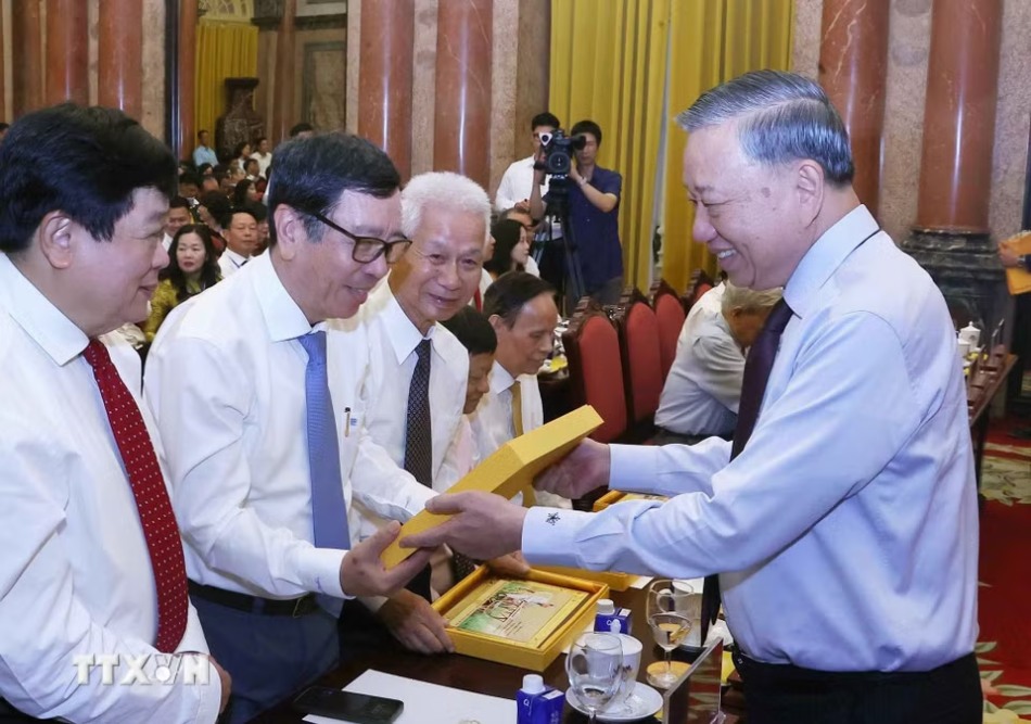 General Secretary and President To Lam presents souvenirs to delegates at the meeting of 101 typical journalists who won the National Press Award over the years held on June 16. Photo: VNA