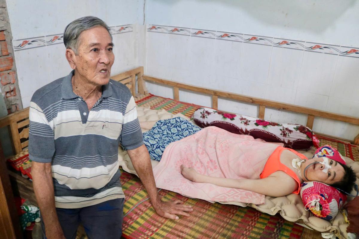 Ông Trương Văn Việt vẫn chăm sóc người con gái bất hạnh là chị Trương Thị Trúc Phương mỗi ngày. Ảnh: Hương Nha