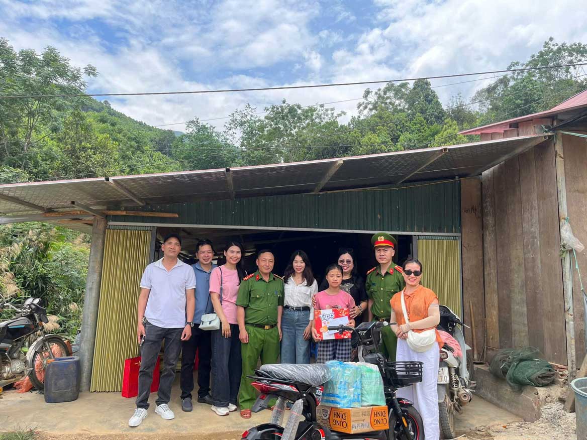 Công an xã Mỏ Vàng cùng các nhà hảo tâm trao tặng xe đạp điện và nhu yếu phẩm cho cháu Phùng Thị Cải. Ảnh: CA Lào Cai