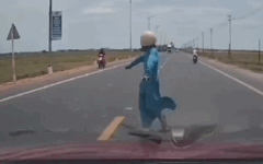 Mujer acostada bloqueando la parte delantera de un coche en circulación, la policía de tráfico interviene para verificar. Foto: Cámara de salpicadero