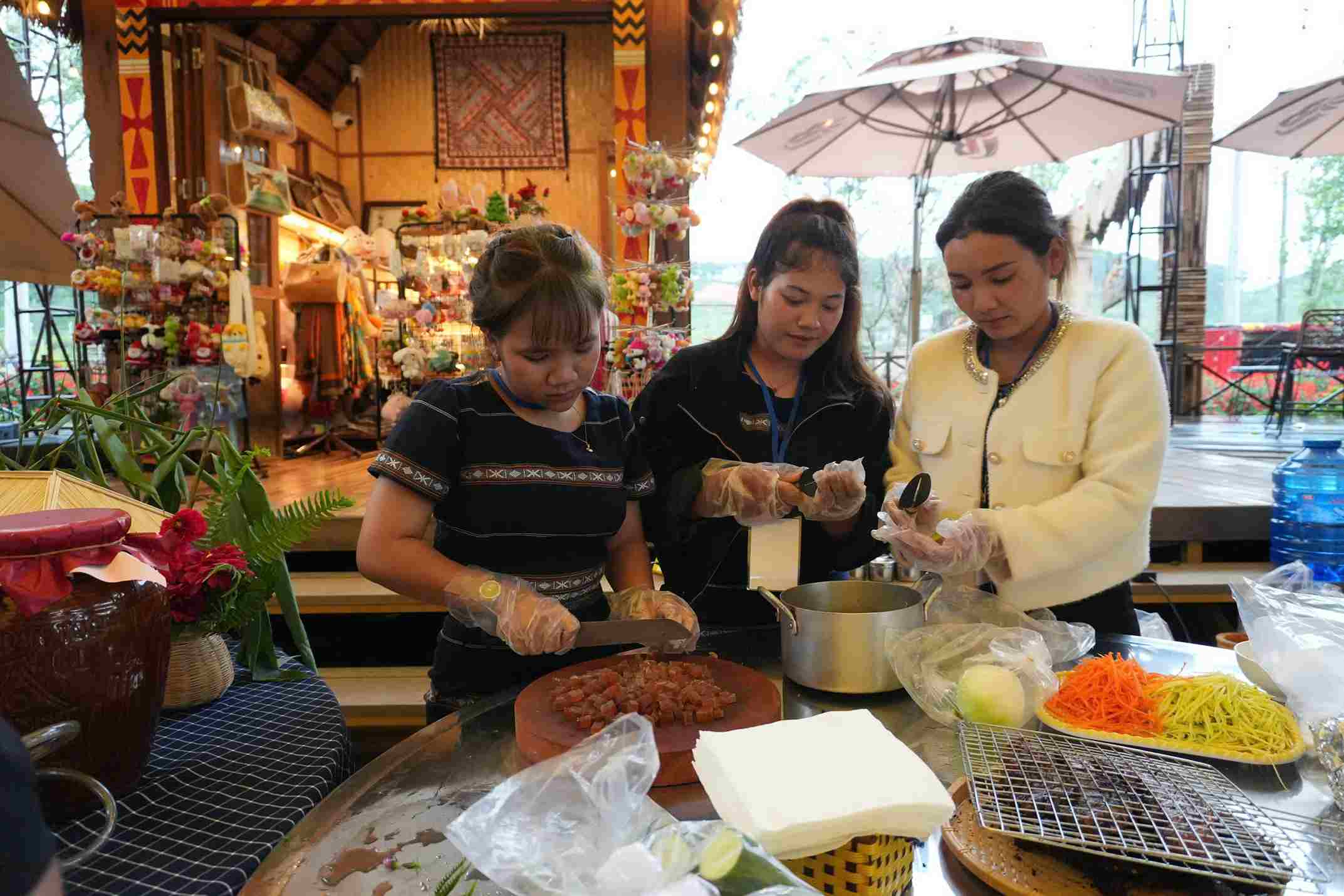 Các cô gái người K'Ho đang chuẩn bị nguyên liệu nấu món cà đắng da trâu - đặc sản của người K'Ho. Ảnh: Phúc Khánh