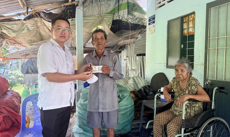 Representatives of the Vietnam Fatherland Front Committee of Tai Van commune present money from readers of Lao Dong Newspaper to support Mr. Son Hoach's situation. Photo: Phuong Anh
