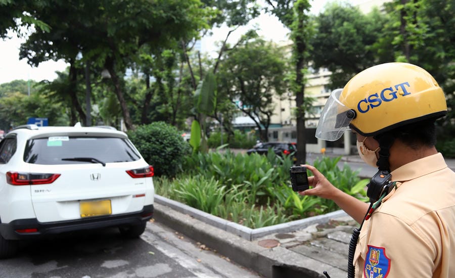Traffic police handle vehicles parked on Kim Ma street. Photo: The Ky