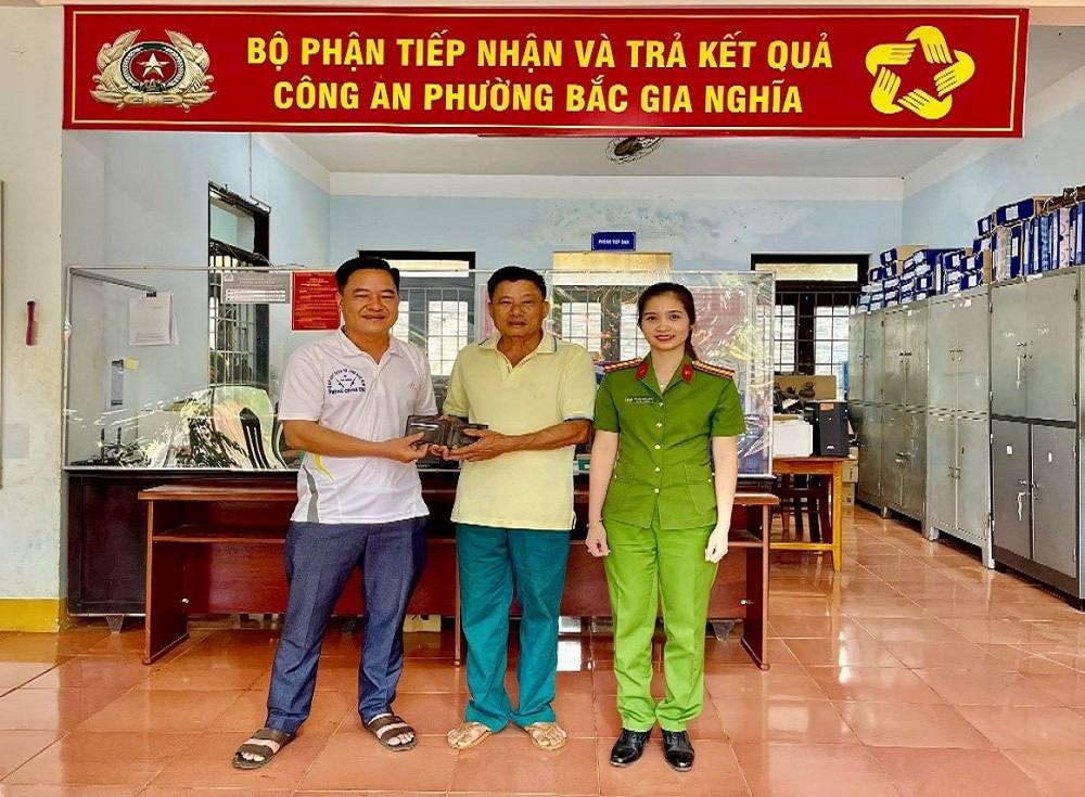 Anh Phạm Văn Thái (bên trái) trao trả tài sản nhặt được cho anh Phan Đình Lợi (ở giữa) tại trụ sở Công an phường Bắc Gia Nghĩa. Ảnh: Công an
