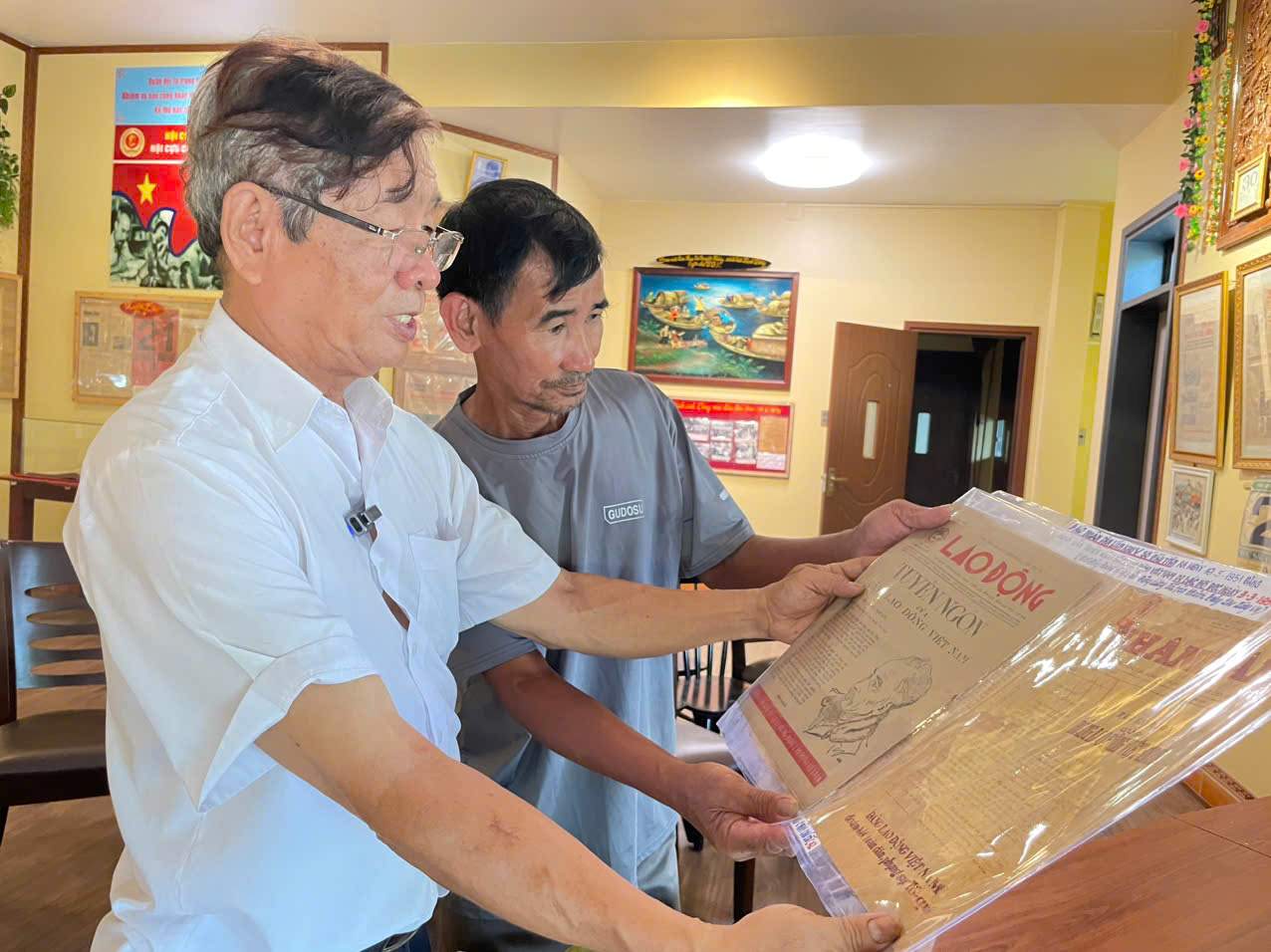 Mr. Nguyen Tien Binh (white shirt) who collects and preserves works of Vietnamese Revolutionary Journalism. Photo: Dinh Trong