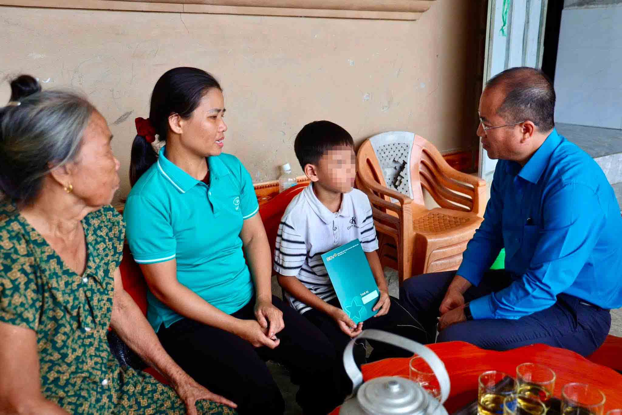 Mr. Nguyen The Hoan - Chairman of Ha Tinh Provincial Labor Federation - presents support money from the sponsoring unit to orphans who are children of workers in Ha Tinh. Photo: Mai Anh