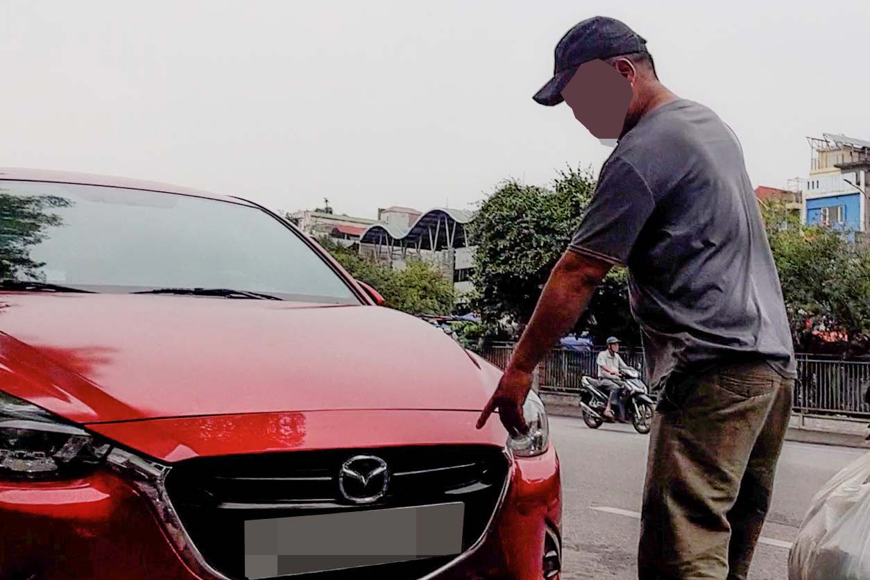 Thợ đóng biển hướng dẫn cách lắp biển số xe giả cho khách. Ảnh: Nhóm phóng viên