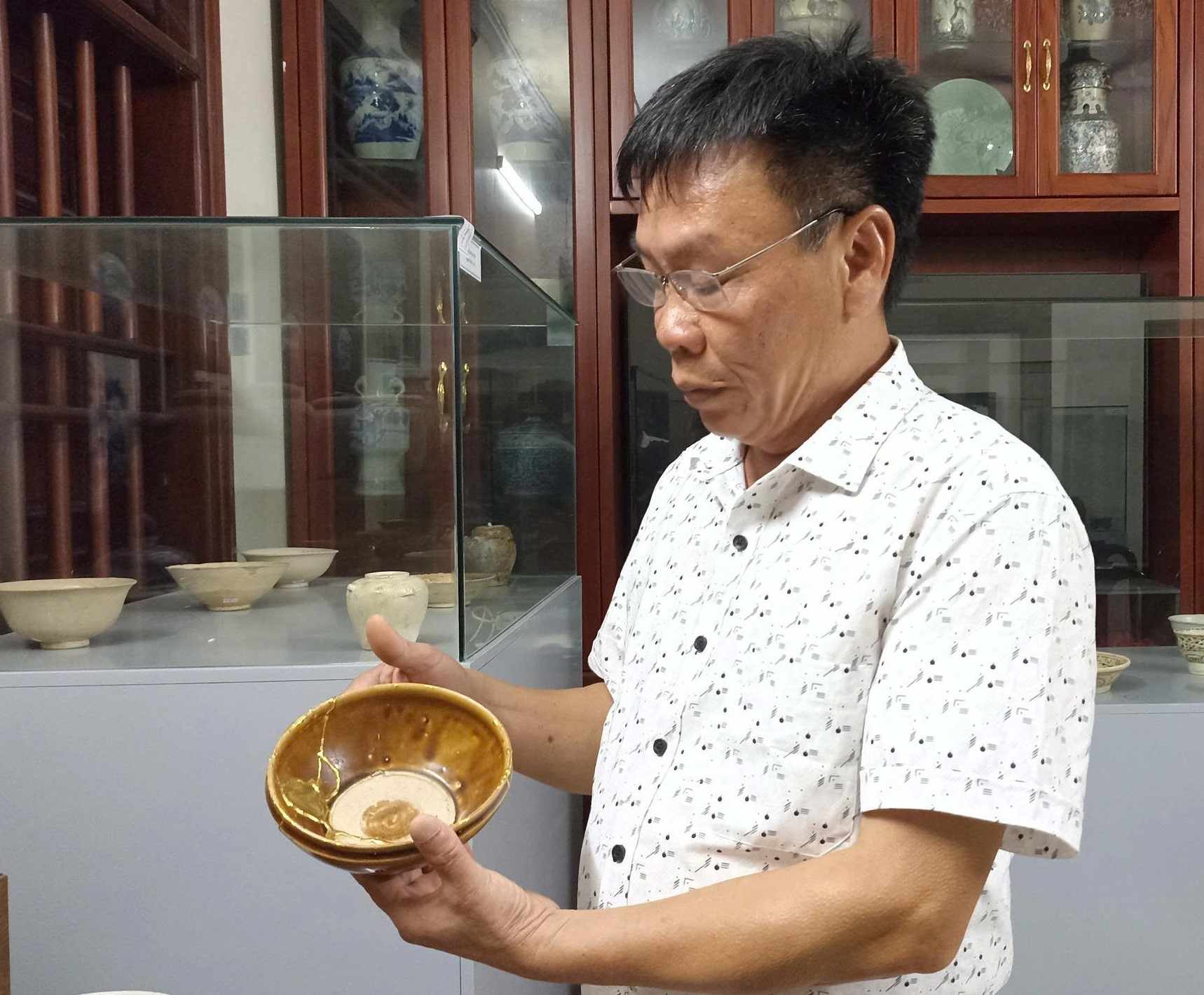 Ông Nguyễn Mạnh Cường giới thiệu về những cổ vật mà ông đã sưu tầm được. Ảnh: Nguyễn Trường