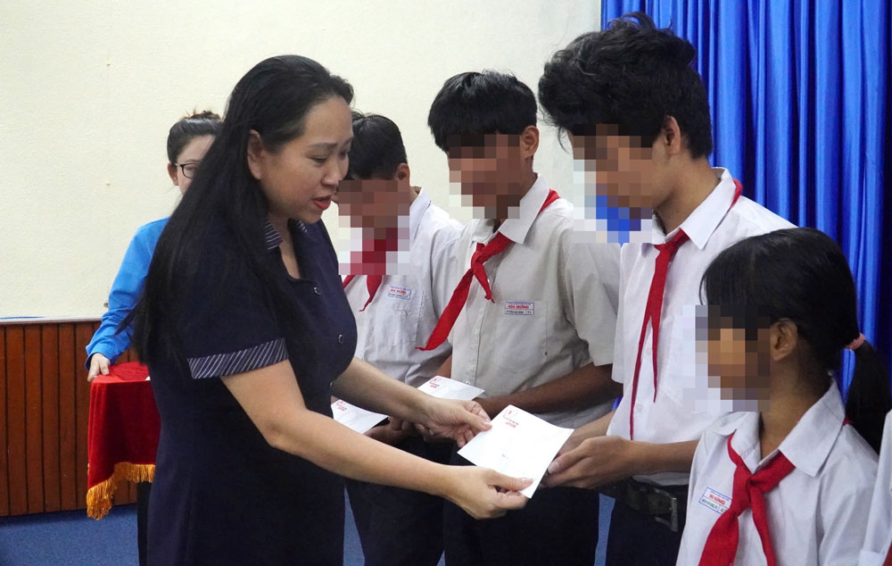 Đại diện Báo Lao Động trao học bổng cho con công nhân vượt khó học giỏi. Ảnh: HAC