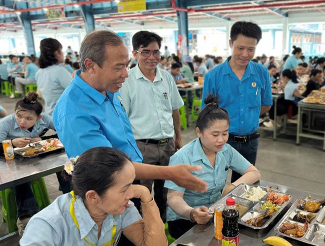 Chairman of the Trade Union of Nam Ha Vietnam Footwear Co., Ltd. Le Trong Thai (standing at the far right) and Chairman of the Lam Dong Provincial Labor Federation Nguyen Phu Hoang (standing at the far left) at the Trade Union Meal. Photo: Duy Tuan