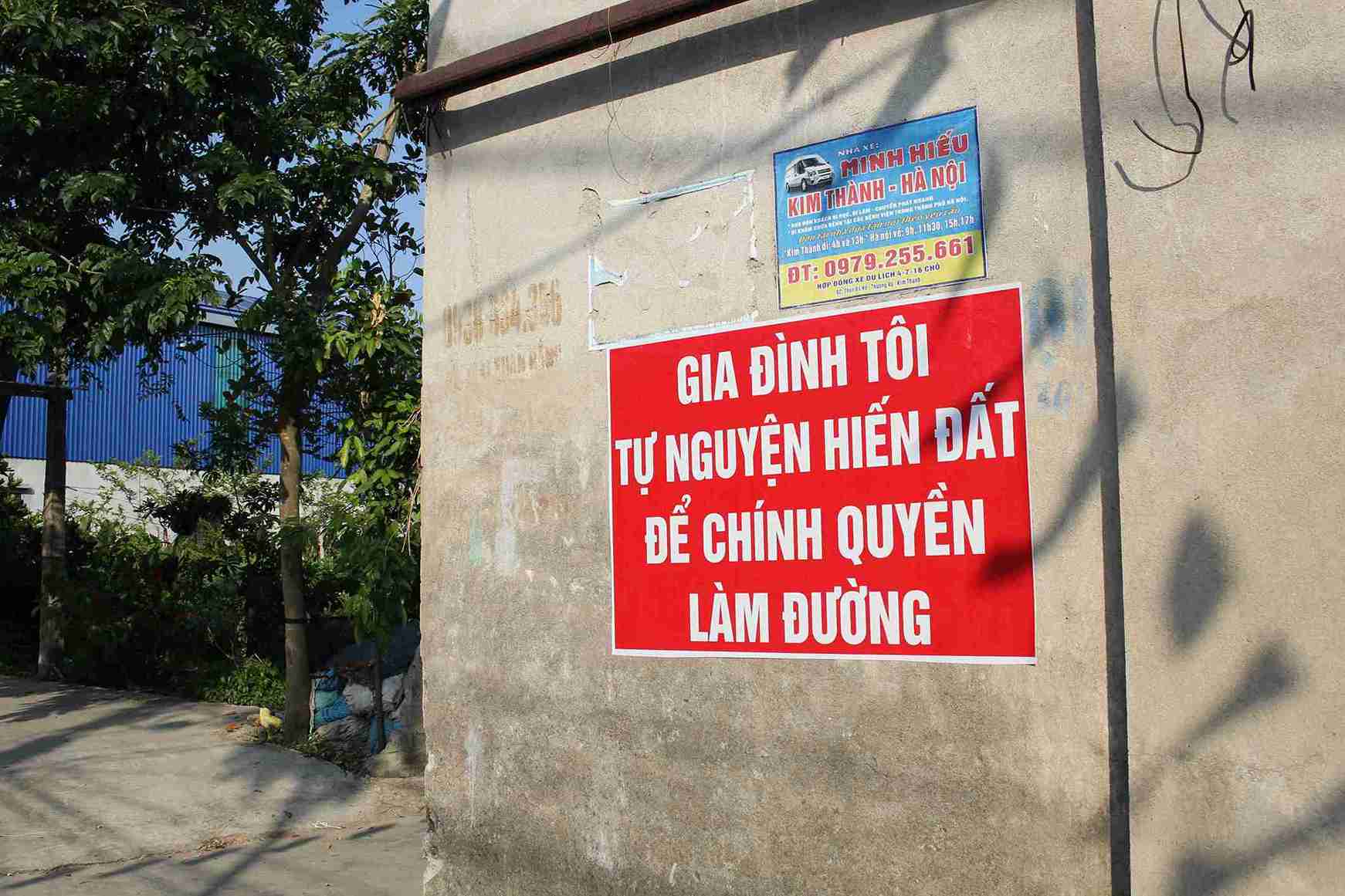 Tấm biển với dòng chữ “Gia đình tôi tự nguyện hiến đất để chính quyền làm đường” xuất hiện trước nhiều ngôi nhà ở thôn Thượng Đỗ. Ảnh: Mai Hương
