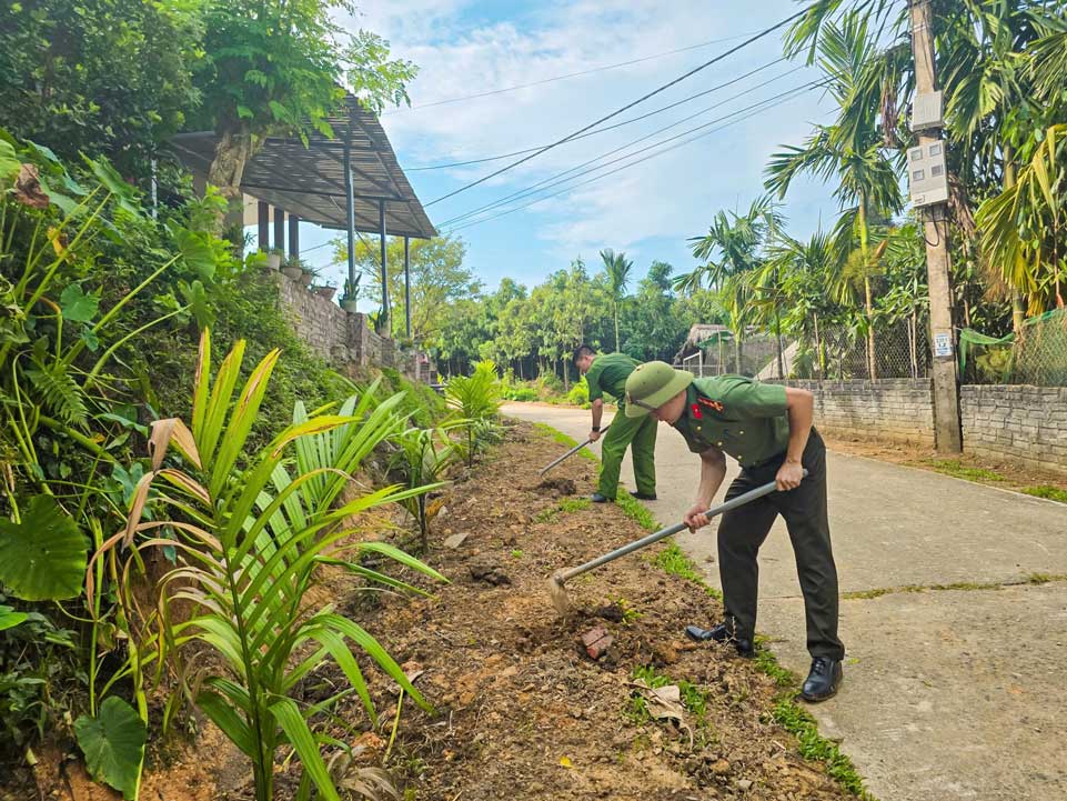 Cán bộ, chiến sĩ Công an xã Quy Mông tham gia trồng cây xanh, xây dựng tuyến đường xanh - sạch - đẹp trên địa bàn. Ảnh: CA Lào Cai