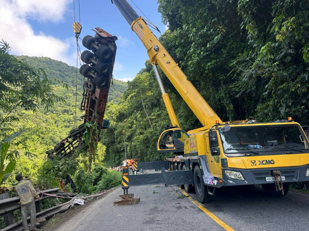 Scene of towing a tractor-trailer car that fell into Bao Loc Pass after a chain collision