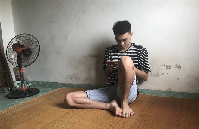 Nam công nhân giải trí bên chiếc điện thoại sau giờ làm. Ảnh: Thu Hiền.