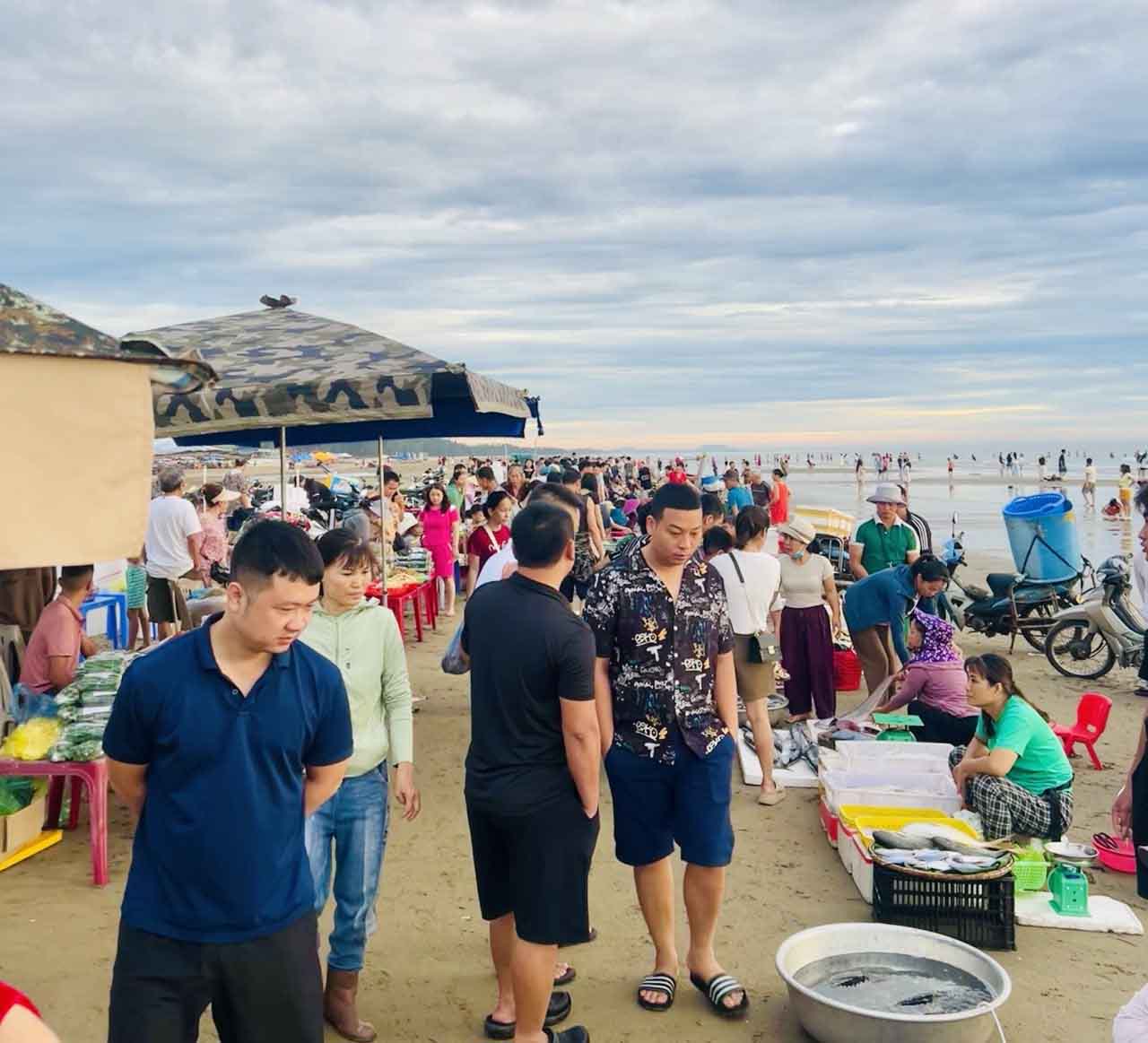 Du khách tấp nập đi chợ cá buổi sáng ở biển Hải Hòa. Ảnh: Linh Boo