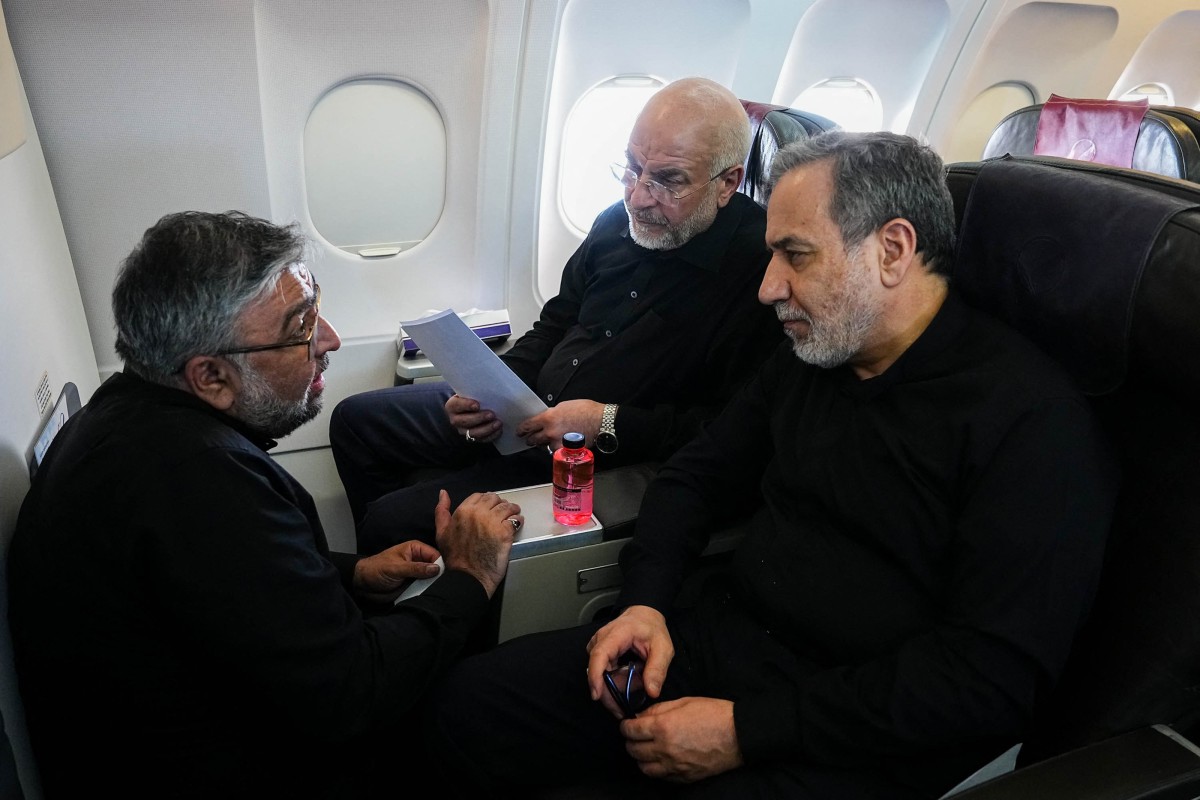 Iranian Parliament Speaker and head of the Iranian negotiating delegation Mohammad Bagher Ghalibaf (center) and Iranian Foreign Minister Abbas Araghchi (right) are exchanging with a member of the Iranian delegation on a flight to negotiate in Zurich, Switzerland on June 21. Photo: AFP