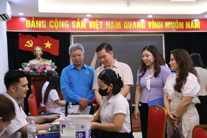 Các ông Đinh Sỹ Đạt - Chủ tịch Công đoàn phường Hoàn Kiếm (thứ nhất từ trái sang, hàng đứng) và ông Nguyễn Huy Khánh - Phó Chủ tịch LĐLĐ Thành phố Hà Nội (thứ 2 từ trái sang, hàng đứng) thăm hỏi đoàn viên, người lao động tại buổi khám sức khỏe do Công đoàn phường phối hợp tổ chức nhân Tháng Công nhân năm 2026. Ảnh: CĐCS