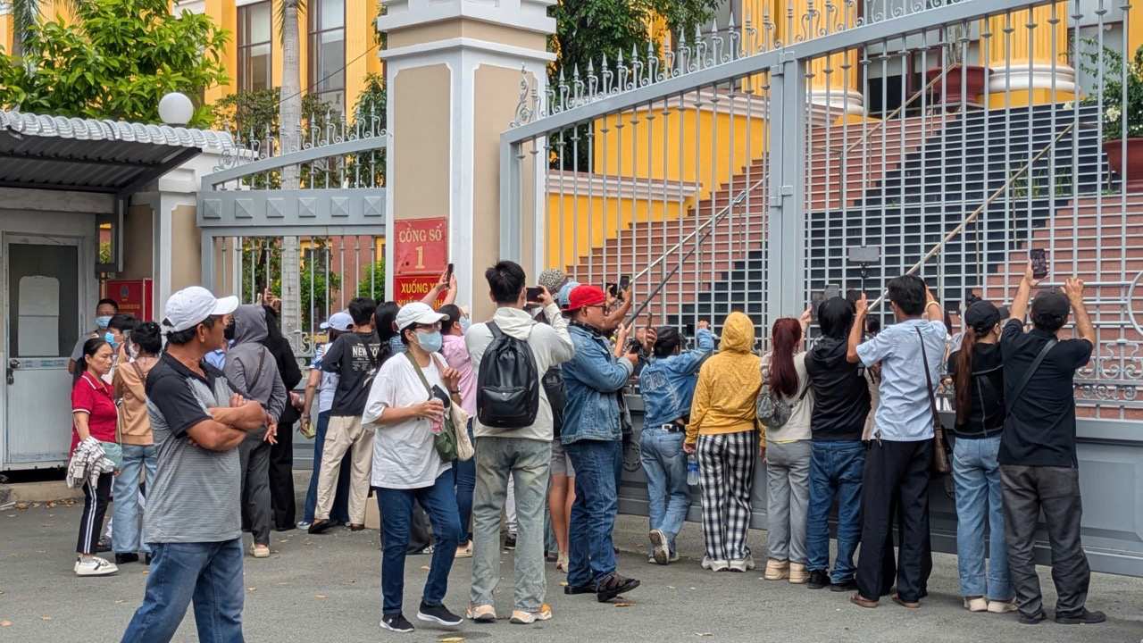 Người dân theo dõi tại cổng của tòa án.