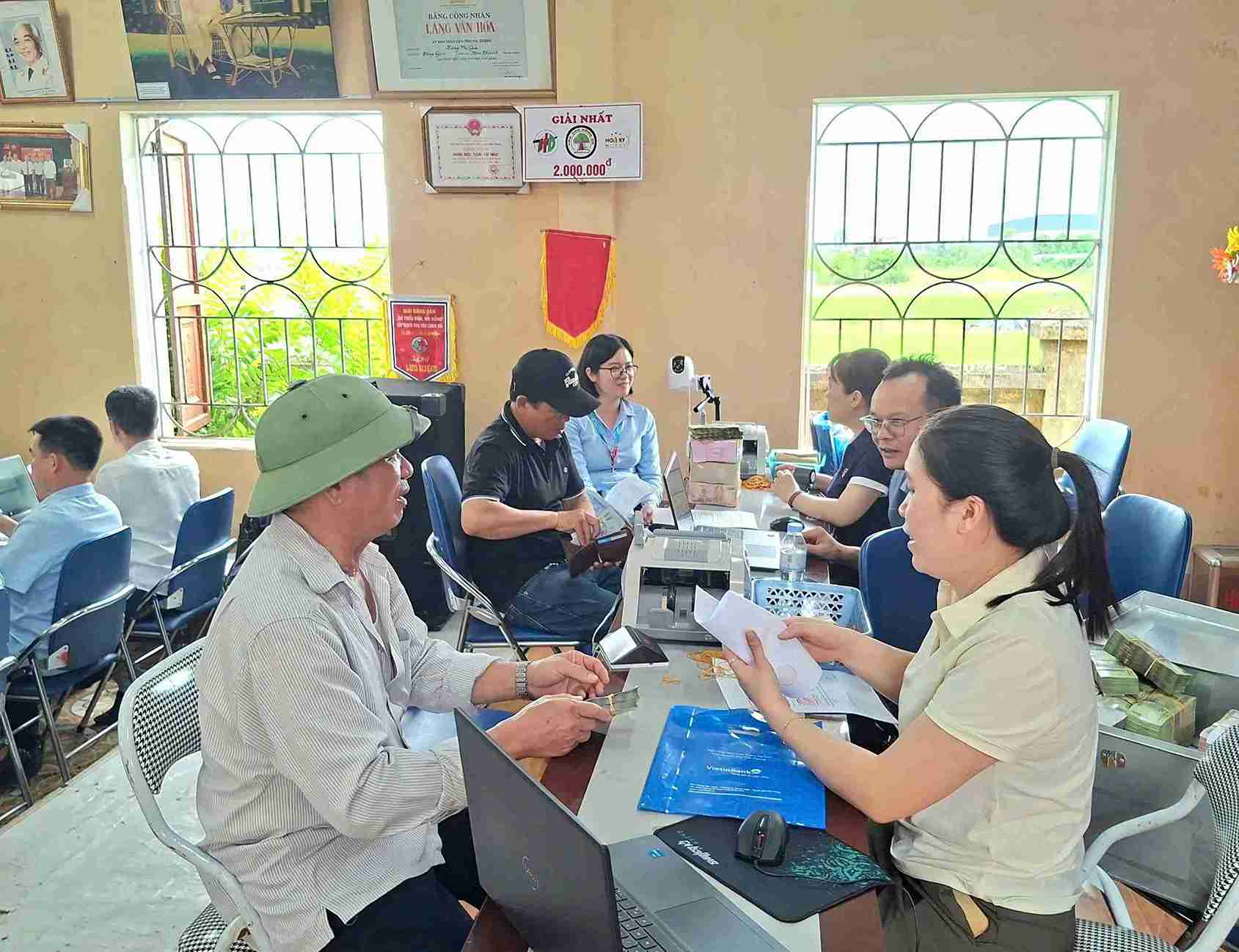 Các hộ dân Thôn Phí Gia nhận tiền chi trả bồi thường. Ảnh: Xã Kim Thành