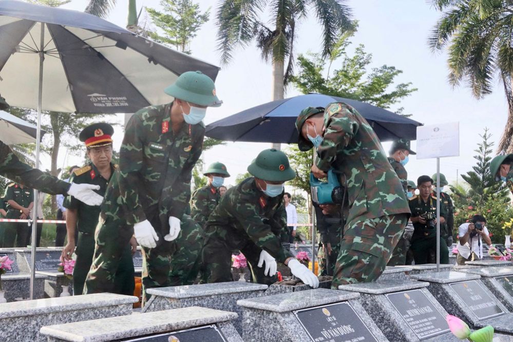 Lực lượng chuyên môn tiến hành lấy mẫu hài cốt liệt sĩ. Ảnh: Việt Tiến
