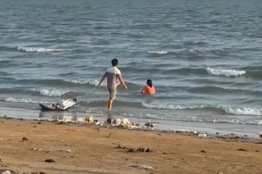 Hình ảnh người đàn ông mang rác thải bỏ xuống biển. Ảnh cắt từ clip
