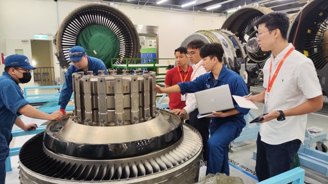 Mr. Phuoc (white shirt in the middle) surveys at the maintenance facility, the initiative of his colleague contributed to making a profit of about 72 billion VND for the business. Photo: Provided by the character.
