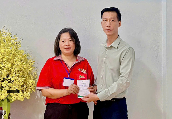 Nữ tài xế (áo đỏ) được lãnh đạo Công ty khen thưởng. Ảnh: Thanh Tuấn