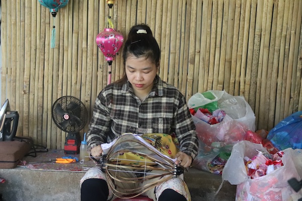 Chị Lê Thị Lan (37 tuổi), làm việc tại công đoạn trang trí dán vải lồng đèn. Ảnh: Nguyễn Linh