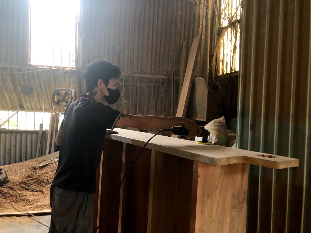 Anh Phú đeo khẩu trang làm việc trong xưởng gỗ, dưới thời tiết gần 40 độ. Ảnh: Quỳnh Chi