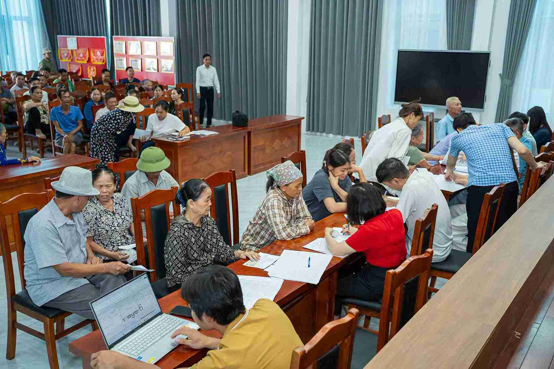 Người dân thôn Đại Hạnh làm thủ tục nhận tiền bồi thường, hỗ trợ tại buổi chi trả. Ảnh: Xã Hoàn Long