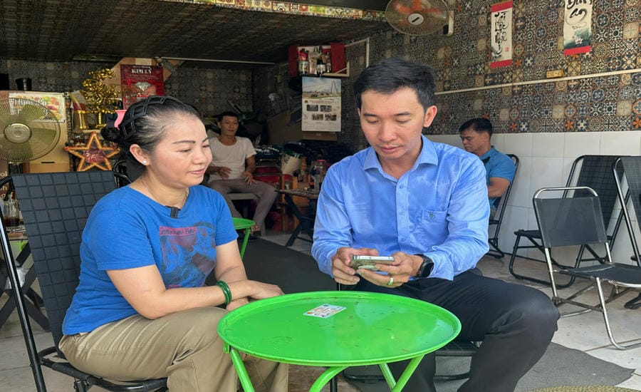 Mr. Luong Quang Nhat Minh - specialist of the Economic, Infrastructure and Urban Department, An Dong Ward People's Committee - guides people to operate on the sidewalk toll collection app. Photo: Minh Tam