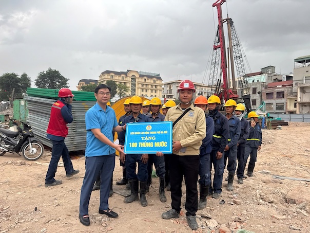 Mr. Nguyen Van Thang - Member of the Standing Committee of the General Confederation, Chairman of the Hanoi Labor Federation presented 100 buckets of water to union members and workers working at the Tran Hung Dao Bridge Construction Project. Photo: CĐHN