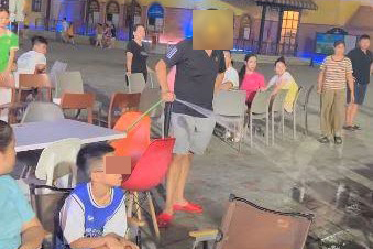 A person used a water hose to spray on a tourist sitting in the Cua Lo beach area. Photo: Ngoc Anh