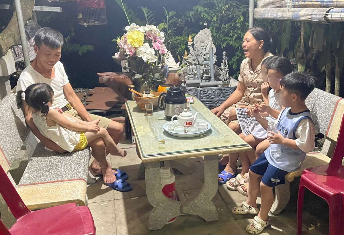 Ông bà quây quần cùng các cháu trên bàn trà nhỏ trước hiên nhà. Ảnh: Nhân vật cung cấp