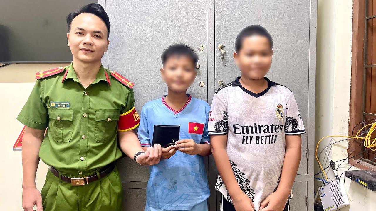 Two students hand over the found wallet to the Hoan Lao commune police. Photo: Hoan Lao commune police