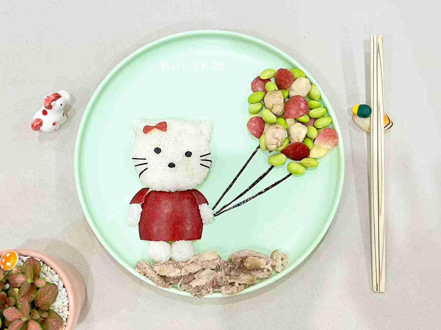A plate of rice shaped like Hello Kitty with a cluster of brilliant, vivid balloons like a colorful and lovely childhood picture. Photo: Character provided