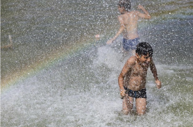 Children cool down and play at the fountain in hot weather in front of the Eiffel Tower in Paris, France, June 23. Photo: Xinhua