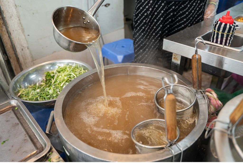 Để nước dùng luôn trong, người đứng bếp phải liên tục vớt bọt. Ảnh: Ngọc Hà