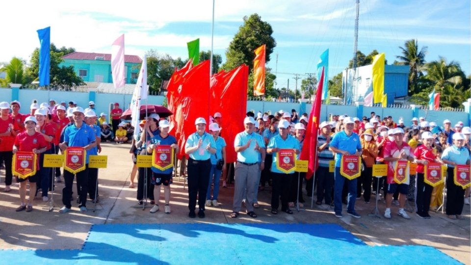 Lãnh đạo xã Nhơn Phú trao cờ lưu niệm cho các đoàn vận động viên tham dự Đại hội Thể dục thể thao lần thứ I. Ảnh: Hoàng Lộc