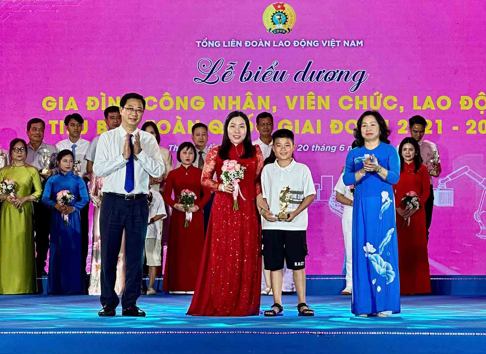 Ms. Lanh and her son at the ceremony to commend typical families of workers, civil servants, and laborers organized by the Vietnam General Confederation of Labor. This is a very proud moment for families. Photo: Mai Anh