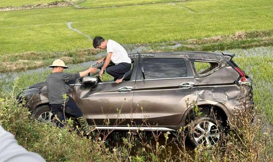 Une voiture 7 places plonge dans un champ après une collision avec une moto de grosse cylindrée. Photo: Hoàng Anh