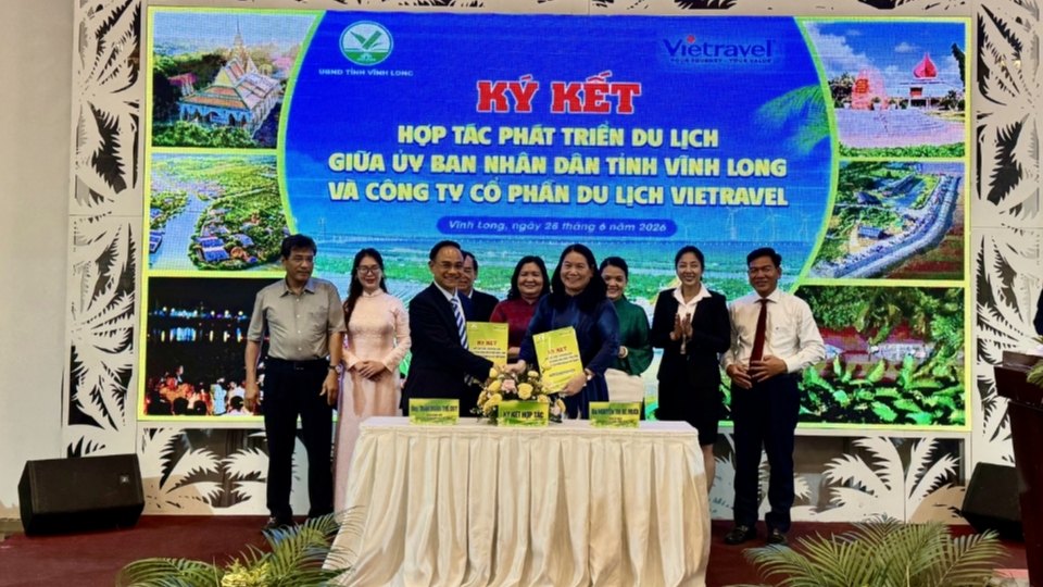 Leaders of Vinh Long Provincial People's Committee and Vietravel Tourism Joint Stock Company perform the signing ceremony of cooperation in the presence of delegates. Photo: Hoang Loc