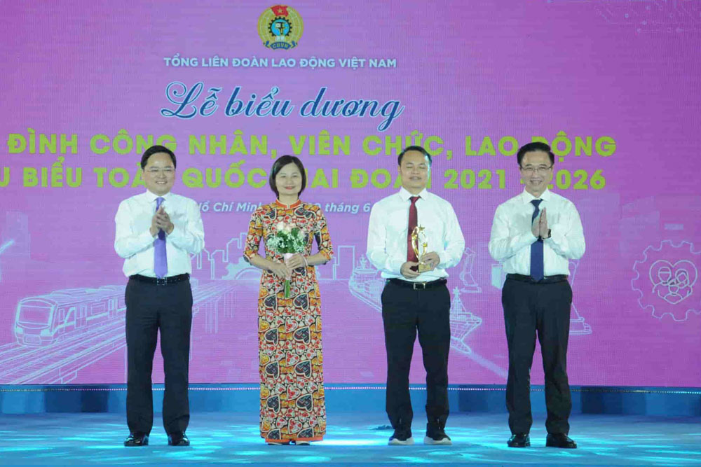 Mr. Nguyen Anh Tuan (left cover) - Member of the Party Central Committee, Chairman of the Vietnam General Confederation of Labor praises the family of Mr. Dang Van Hoa at the Conference to commend 95 typical families of workers, civil servants, and laborers nationwide in the period 2021-2026. Photo: Provided by the character.