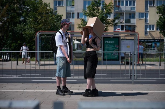 A woman uses a cardboard box to shield herself from the intense heat in Warsaw, Poland, June 27. Photo: Xinhua