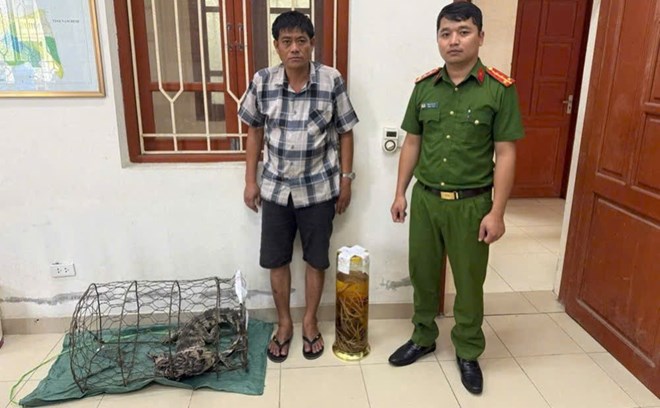 Bùi Ngọc Tài cùng tang vật trong vụ bình rượu ngâm tay gấu. Ảnh: Công an cung cấp