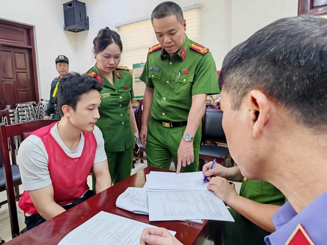 Công an Hà Nội lấy lời khai đối tượng trong đường dây lừa đảo "hợp đồng kỳ nghỉ". Ảnh: CAHN