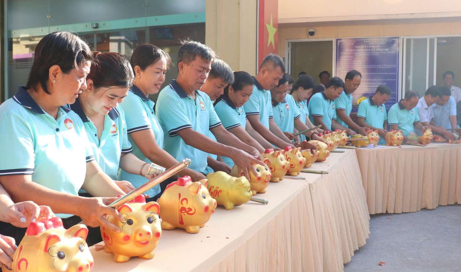 Đại diện các Ban Công tác Mặt trận các ấp thực hiện đập heo đất tiết kiệm, đóng góp vào Quỹ “Vì người nghèo” và Quỹ “Vì biển đảo quê hương - Vì tuyến đầu Tổ quốc” năm 2026. Ảnh: Thái Bảo.